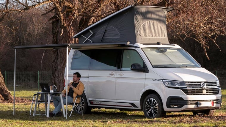 Man at Table in front of Campervan 