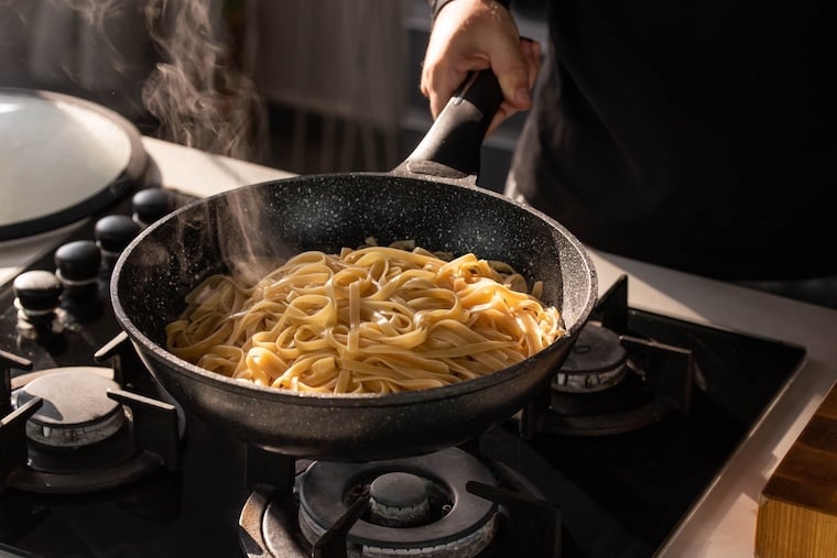 Pasta cooking on stove in campervan